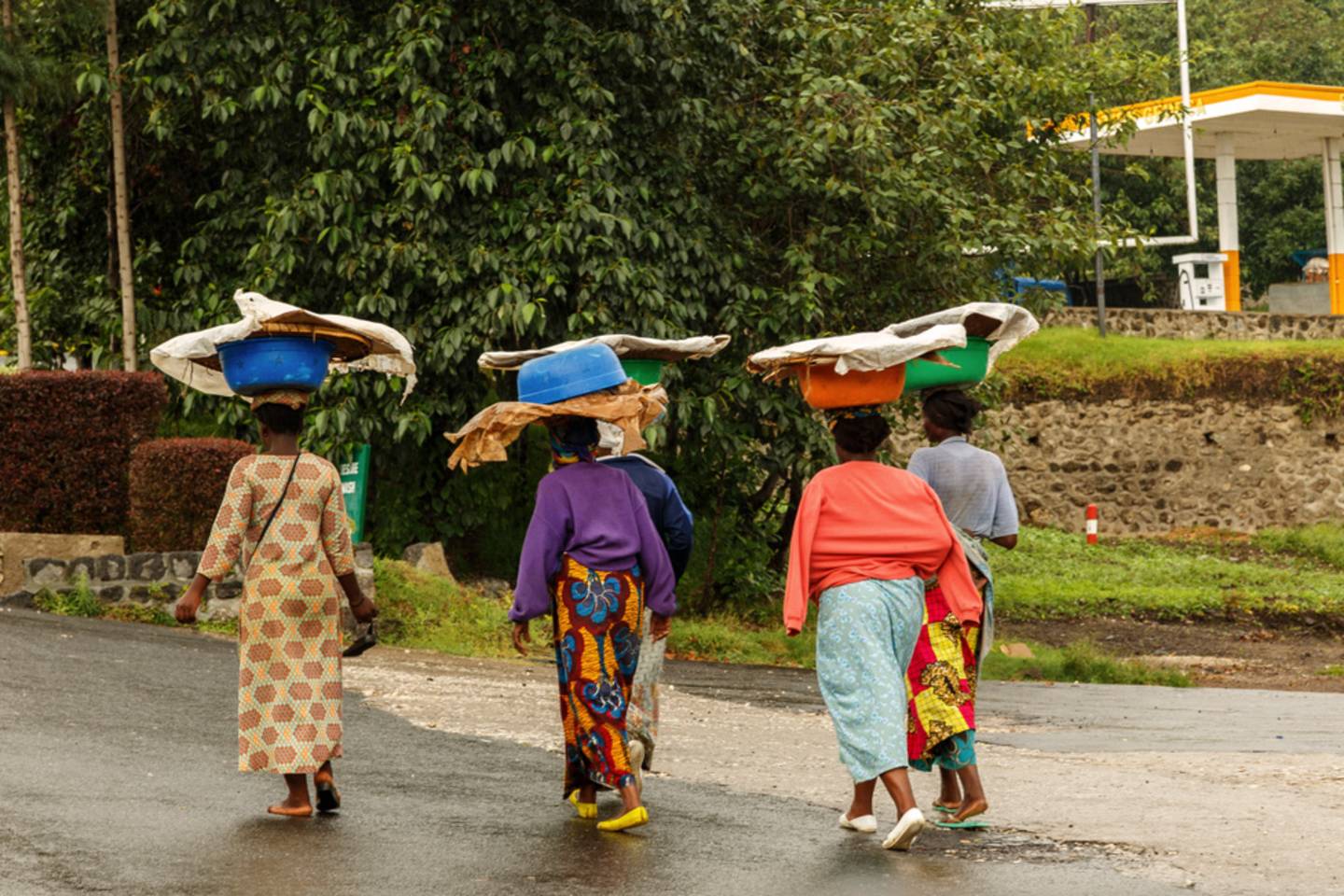 four women walking with baskets on heads